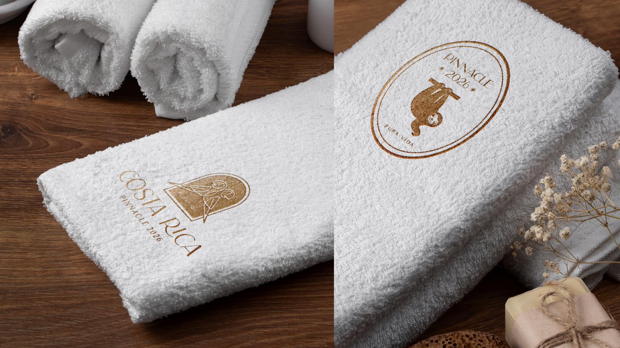 White towels embroidered with the Costa Rica Pinnacle 2026 logo
